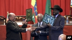 Sudan's President Omar al-Bashir, left, and S. Sudan President Salva Kiir, shake hands on the completion of a signing ceremony in Addis Ababa, Ethiopia, September 27, 2012. 