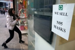 A woman walks into a pharmacy to purchase N95 face masks in advance of the potential coronavirus outbreak in the Manhattan borough of New York City, Feb. 27, 2020.