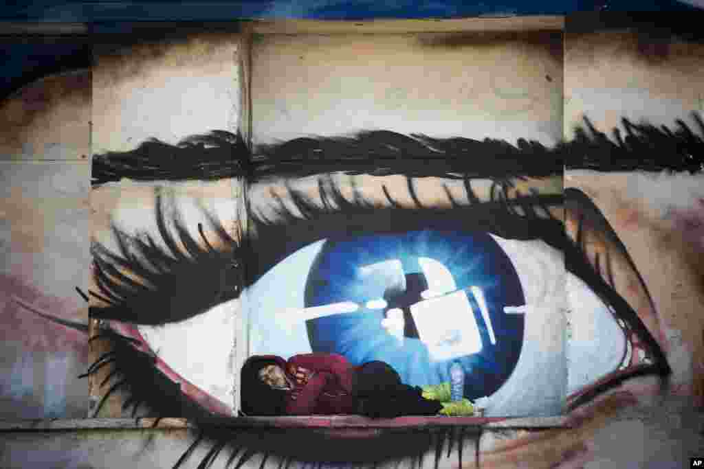 A refugee sleeps outside an abandoned building at the port of Mytilini, Lesbos island, Greece. Austrian Chancellor and the Greek premier visited Lesbos island to view the impact of the refugee crisis and tour facilities set up to handle the thousands of people who arrive daily.