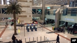 FILE - Airport staff gather near a security checkpoint at Cairo International Airport, March 21, 2017. The airport has started screening passengers arriving from Sudan for signs of cholera.