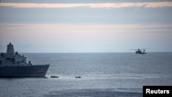 FILE - A supplied image obtained from the U.S. Defense Force, Aug. 6, 2017, shows search efforts for three U.S. Marines missing after their MV-22 Osprey tilt-rotor aircraft crashed into the sea off Australia's northeast coast. 