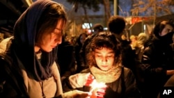 FILE - People gather for a candlelight vigil to remember the victims of the Ukraine plane crash, at the gate of Amri Kabir University that some of the victims of the crash were former students of, in Tehran, Iran, Jan. 11, 2020. 