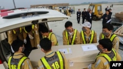 FILE - This Vietnam News Agency photo taken Nov. 27, 2019, shows remains of one of the Vietnamese smuggling victims who died in Britain being transferred to an ambulance at Noi Bai International Airport in Hanoi.