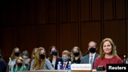 U.S. Supreme Court nominee Judge Amy Coney Barrett reacts as she sits in front of her children and her husband Jesse Barrett during the second day of her confirmation hearing before the Senate Judiciary Committee on Capitol Hill in Washington, D.C.