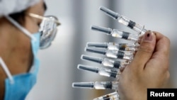A worker performs a quality check in the packaging facility of Chinese vaccine maker Sinovac Biotech, developing an experimental coronavirus disease (COVID-19) vaccine, during a government-organized media tour in Beijing, Sept. 24, 2020.