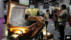 Visitors look at a paper casket at the Asia Funeral and Cemetery Expo & Conference in Hong Kong, May 18, 2017. 
