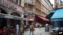 A man walks by restaurants in Lyon, central France, July 13, 2021.