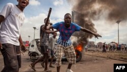 Demonstrators gather in front of a burning car during an opposition rally in Kinshasa, DRC, Sept. 19, 2016.