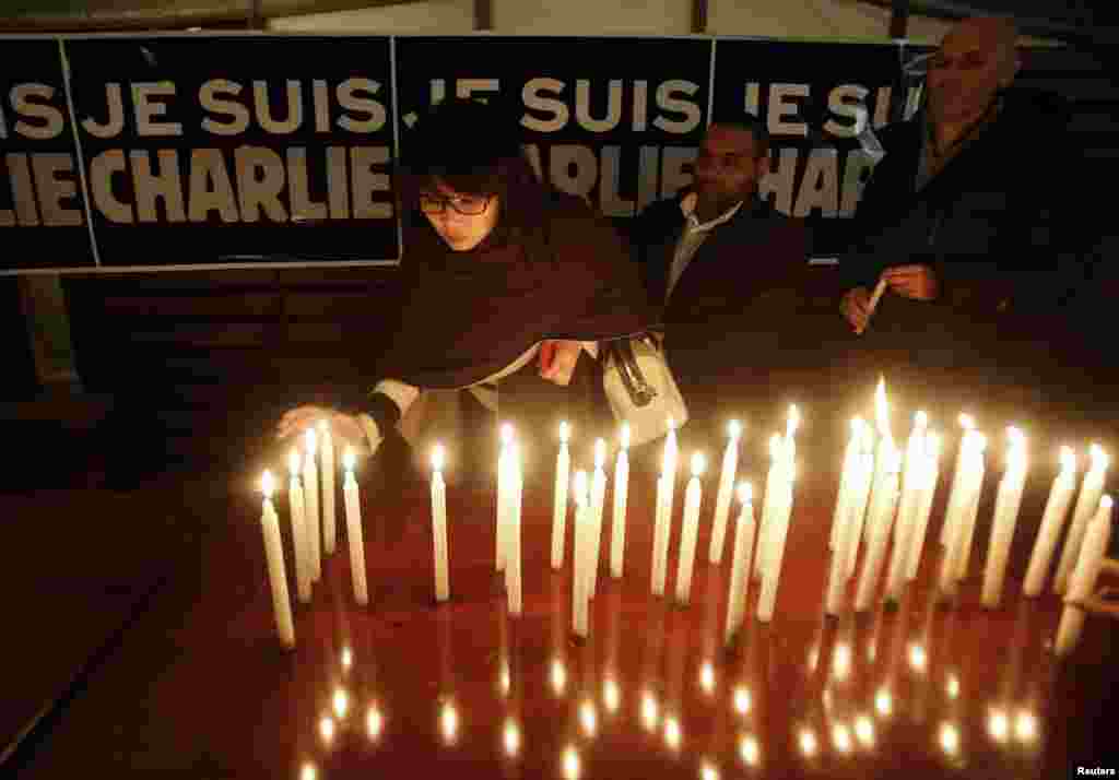 Candles are placed in front of a banner that reads "I am Charlie" at the French Embassy in Hanoi, Vietnam, Jan. 8, 2015.