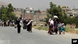 ফাইল - দামাস্কাসের কাছে বিদ্রোহী-নিয়ন্ত্রিত মোয়াদামিয়েহ মফস্বলে পণ্যসামগ্রী নিয়ে ফিরছে সাধারণ মানুষ। ১৪ জুলাই, ২০১৪।