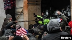 Partidarios del entonces presidente Donald Trump se enfrentan a la policía en la entrada oeste del Capitolio durante una protesta "Stop the Steal" frente al edificio del Capitolio en Washington DC, el 6 de enero de 2021.