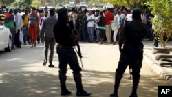 Policemen stand guard as supporters of Indigenous People of Biafra leader Nnamdi Kanu rallies before appearance in magistrate court, Abuja, Nigeria, Dec. 1, 2015.