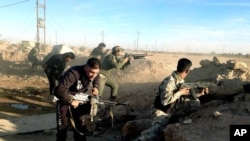 Iraqi security forces take combat positions on the front line with Islamic State group militants in Ramadi, capital of Anbar province, 70 miles (115 kilometers) west of Baghdad, Dec. 10, 2015.
