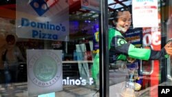 FILE - The 'halal' logo of the Indonesian Ulema Council is displayed on the facade of a restaurant in Jakarta, Indonesia, Nov. 11, 2020.