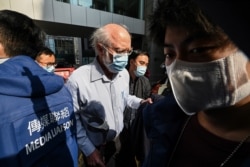 John Clancey, a US solicitor with law firm Ho Tse Wai and Partners that is known for taking on human rights cases is led away by police after he was arrested in Hong Kong on Jan.y 6, 2021.