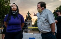 Two people disagree on removal of the Emancipation Memorial, in Lincoln Park, Washington, in this image released by World Press Photo, April 15, 2021, by Evelyn Hockstein for The Washington Post, which placed first in the Spot News Singles category.