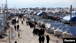 FILE - Women walk through al-Hol displacement camp in Hasaka governorate, Syria, April 1, 2019. There has long been worry about a potential coronavirus outbreak in northeastern Syria, home to several displaced-person and refugee camps.