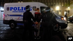 New York Police officers escort a protester outside the Columbia University campus, April 30, 2024, in New York.