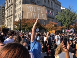 A Joe Biden supporter holds up a message for President Donald Trump during a rally near the White House, Nov. 7, 2020. (Margaret Besheer/VOA)