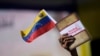Una mujer sostiene una bandera venezolana y un libro sobre la disputa del territorio del Esequibo en Caracas, el 29 de noviembre de 2023. 