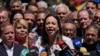 La candidata presidencial opositora María Corina Machado ofrece un discurso a las afueras de su comando de campaña en Caracas, el 29 de enero de 2024, flanqueada por dirigentes de partidos del antichavismo.