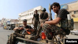 FILE - Houthi militants patrol a street where pro-Houthi protesters demonstrated against the Saudi-led coalition in Hodeida, Yemen, Dec. 10, 2018.