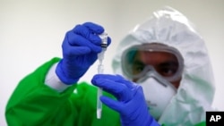 A medical worker practices conducting rapid COVID-19 tests on his colleagues at Beatriz Velasco de Aleman Health Center, in the Venustiano Carranza borough of Mexico City, Nov. 20, 2020.