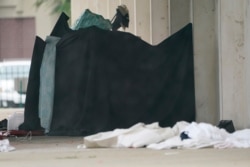 A homeless resident takes refuge in a makeshift shelter at a shuttered restaurant in downtown Jackson, Miss., Aug. 30, 2021, the day after Hurricane Ida made landfall.