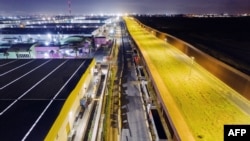FILE - Aerial view showing trucks queuing near the Mexico-US border while waiting for the port to open in Otay Commercial crossing in Tijuana, Baja California state, Mexico, on March 4, 2025. 