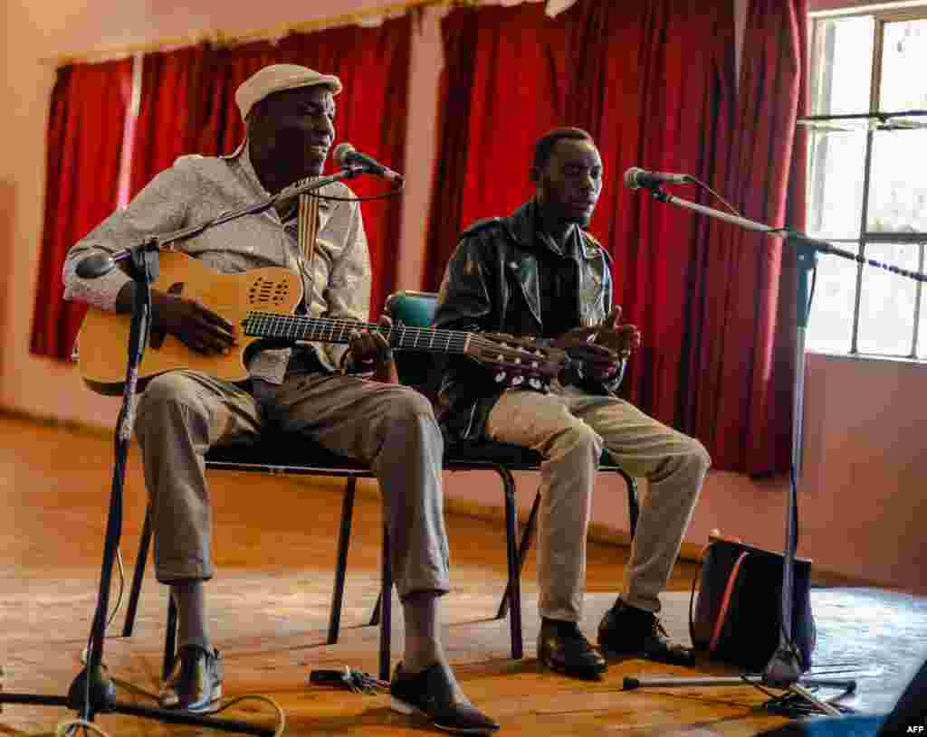 Zimbabwe music icon Oliver 'Tuku' Mtukudzi (L) plays his guitar during a rehearsal with a group of young musicians who are incubated at his Pakare Paye Arts and Music Centre in Norton 45km from the country's capital city Harare on January 12, 2018. / AFP PHOTO / Jekesai NJIKIZANA
