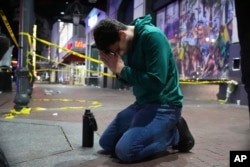 Matthias Hauswirth of New Orleans prays on the street near the scene where a vehicle drove into a crowd on New Orleans' Canal and Bourbon streets, Jan. 1, 2025.