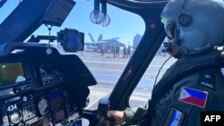 A pilot executes a final check in a Philippine Navy helicopter on the deck of the USS Carl Vinson during joint patrol exercises with the United States in the South China Sea on Jan. 4, 2023. (Armed Forces of the Philippines via AFP)