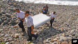 French police officers carry a piece of debris from a plane in Saint-Andre, Reunion Island, July 29, 2015.