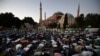 FILE - Muslims offer their evening prayers outside the Byzantine-era Hagia Sophia in Istanbul, following Turkey's decision allowing the government to convert the museum back into a Muslim house of worship, July 10, 2020. 
