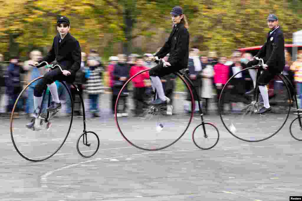 Participants wearing historical costumes ride their high-wheel bicycles during the annual penny farthing race in Prague, Czech Republic, Nov. 2, 2024, 