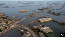 FILE - Homes are surrounded by floodwaters in Sohbat Pur city, a district of Pakistan's southwestern Baluchistan province, August 29, 2022. . (AP Photo/Zahid Hussain, File)