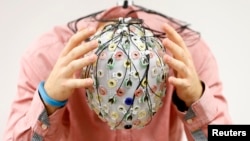 FILE - Test person Niklas Thiel poses with an electroencephalography (EEG) cap which measures brain activity, at the Technische Universitaet Muenchen (TUM) in Garching near Munich September 9, 2014. (REUTERS/Michaela Rehle)