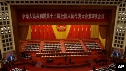 With screens showing Chinese President Xi Jinping, delegates attend the opening session of China's National People's Congress (NPC) at the Great Hall of the People in Beijing on March 5, 2021. 
