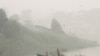 A man rows a boat on Siak River as thick haze from wildfires blanket the city in Pekanbaru, Riau province, Indonesia, Oct. 5, 2015. 