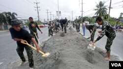 Tentara Thailand dikerahkan untuk membuat tanggul-tanggul pasir guna mencegah masuknya banjir di kawasan Pathum Thani, Bangkok.