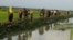 Displaced Rohingya refugees from Rakhine state in Myanmar carry their belongings as they flee violence, near Ukhia, near the border between Bangladesh and Myanmar on September 4, 2017. - A total of 87,000 mostly Rohingya refugees have arrived in Banglades