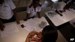 A woman sanitises her hands while undergoing screening at an entrance to the Milpark Hospital in Johannesburg, Wednesday, March 11, 2020 where anyone entering or exiting is required to do as a precaution against the new coronavirus.