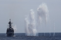 Flares are set off from Kee Lung (DDG-1801) guided-missile destroyer (R) and navy vessels during a military drill near Hualien, Taiwan, May 22, 2019.