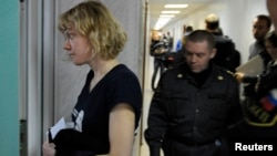 Greenpeace activist Sini Saarela from Finland (L) is escorted at a district court in Murmansk, Russia, Sept. 29, 2013. 