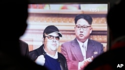 FILE - A TV screen shows pictures of North Korean leader Kim Jong Un and his older brother Kim Jong Nam, left, at the Seoul Railway Station in Seoul, South Korea, Feb. 14, 2017