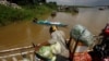 A vendor, foreground, stands on a ferry together with his goods before crossing the Mekong river in Dei Edth village at the outskirt of Phnom Penh, Cambodia, July 22, 2020. 