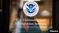 FILE - A woman leaves the U.S. Citizenship and Immigration Services offices in New York, Aug. 15, 2012.