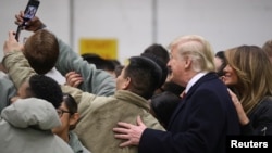 U.S. President Donald Trump and first lady Melania Trump take a selfie with U.S. troops at Ramstein Air Force Base, Germany, Dec. 27, 2018. 