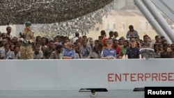 Migrants arrive on the British vessel HMS Enterprise before disembarking in the Sicilian harbour of Catania, Italy, Oct. 6, 2015.