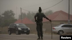 A policeman keeps watch on the road leading to Taraba state electoral commission during the announcement of the results of the Governorship and State assembly elections in Jalingo, Nigeria, April 12, 2015. 